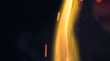 Şenlik ateşi kıvılcımlarının Macro fotoğrafı. Alevler patlar, patlamalar. Patlama mikro parlaklığı. Mini Havai fişekler. Kırmızı kamerada çekim hala siyah arkaplanda. Güzel sızıntılar kıvılcım posteri, afiş, duvar kağıdı, arkaplan, doku.