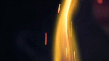 Şenlik ateşi kıvılcımlarının Macro fotoğrafı. Alevler patlar, patlamalar. Patlama mikro parlaklığı. Mini Havai fişekler. Kırmızı kamerada çekim hala siyah arkaplanda. Güzel sızıntılar kıvılcım posteri, afiş, duvar kağıdı, arkaplan, doku.