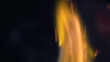 Şenlik ateşi kıvılcımlarının Macro fotoğrafı. Alevler patlar, patlamalar. Patlama mikro parlaklığı. Mini Havai fişekler. Kırmızı kamerada çekim hala siyah arkaplanda. Güzel sızıntılar kıvılcım posteri, afiş, duvar kağıdı, arkaplan, doku.