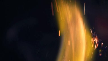 Şenlik ateşi kıvılcımlarının Macro fotoğrafı. Alevler patlar, patlamalar. Patlama mikro parlaklığı. Mini Havai fişekler. Kırmızı kamerada çekim hala siyah arkaplanda. Güzel sızıntılar kıvılcım posteri, afiş, duvar kağıdı, arkaplan, doku.