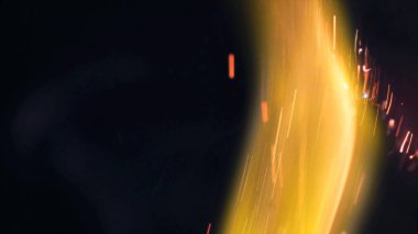 Şenlik ateşi kıvılcımlarının Macro fotoğrafı. Alevler patlar, patlamalar. Patlama mikro parlaklığı. Mini Havai fişekler. Kırmızı kamerada çekim hala siyah arkaplanda. Güzel sızıntılar kıvılcım posteri, afiş, duvar kağıdı, arkaplan, doku.