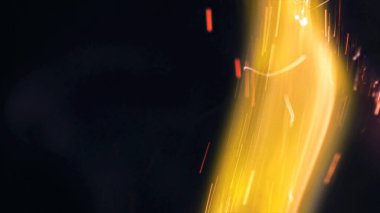 Şenlik ateşi kıvılcımlarının Macro fotoğrafı. Alevler patlar, patlamalar. Patlama mikro parlaklığı. Mini Havai fişekler. Kırmızı kamerada çekim hala siyah arkaplanda. Güzel sızıntılar kıvılcım posteri, afiş, duvar kağıdı, arkaplan, doku.