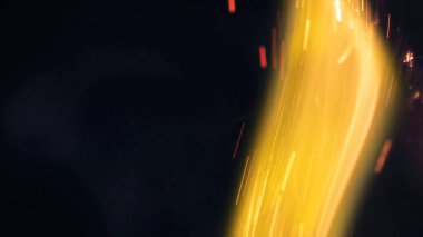 Şenlik ateşi kıvılcımlarının Macro fotoğrafı. Alevler patlar, patlamalar. Patlama mikro parlaklığı. Mini Havai fişekler. Kırmızı kamerada çekim hala siyah arkaplanda. Güzel sızıntılar kıvılcım posteri, afiş, duvar kağıdı, arkaplan, doku.