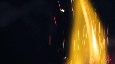 Şenlik ateşi kıvılcımlarının Macro fotoğrafı. Alevler patlar, patlamalar. Patlama mikro parlaklığı. Mini Havai fişekler. Kırmızı kamerada çekim hala siyah arkaplanda. Güzel sızıntılar kıvılcım posteri, afiş, duvar kağıdı, arkaplan, doku.