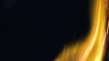 Şenlik ateşi kıvılcımlarının Macro fotoğrafı. Alevler patlar, patlamalar. Patlama mikro parlaklığı. Mini Havai fişekler. Kırmızı kamerada çekim hala siyah arkaplanda. Güzel sızıntılar kıvılcım posteri, afiş, duvar kağıdı, arkaplan, doku.