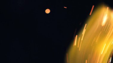 Şenlik ateşi kıvılcımlarının Macro fotoğrafı. Alevler patlar, patlamalar. Patlama mikro parlaklığı. Mini Havai fişekler. Kırmızı kamerada çekim hala siyah arkaplanda. Güzel sızıntılar kıvılcım posteri, afiş, duvar kağıdı, arkaplan, doku.