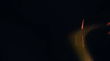 Şenlik ateşi kıvılcımlarının Macro fotoğrafı. Alevler patlar, patlamalar. Patlama mikro parlaklığı. Mini Havai fişekler. Kırmızı kamerada çekim hala siyah arkaplanda. Güzel sızıntılar kıvılcım posteri, afiş, duvar kağıdı, arkaplan, doku.