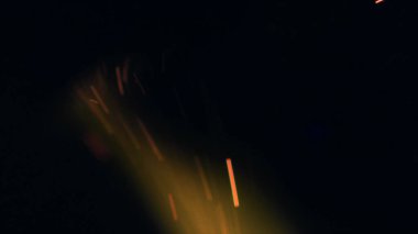 Şenlik ateşi kıvılcımlarının Macro fotoğrafı. Alevler patlar, patlamalar. Patlama mikro parlaklığı. Mini Havai fişekler. Kırmızı kamerada çekim hala siyah arkaplanda. Güzel sızıntılar kıvılcım posteri, afiş, duvar kağıdı, arkaplan, doku.