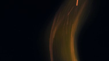 Şenlik ateşi kıvılcımlarının Macro fotoğrafı. Alevler patlar, patlamalar. Patlama mikro parlaklığı. Mini Havai fişekler. Kırmızı kamerada çekim hala siyah arkaplanda. Güzel sızıntılar kıvılcım posteri, afiş, duvar kağıdı, arkaplan, doku.