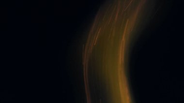 Şenlik ateşi kıvılcımlarının Macro fotoğrafı. Alevler patlar, patlamalar. Patlama mikro parlaklığı. Mini Havai fişekler. Kırmızı kamerada çekim hala siyah arkaplanda. Güzel sızıntılar kıvılcım posteri, afiş, duvar kağıdı, arkaplan, doku.