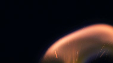 Şenlik ateşi kıvılcımlarının Macro fotoğrafı. Alevler patlar, patlamalar. Patlama mikro parlaklığı. Mini Havai fişekler. Kırmızı kamerada çekim hala siyah arkaplanda. Güzel sızıntılar kıvılcım posteri, afiş, duvar kağıdı, arkaplan, doku.