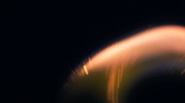 Şenlik ateşi kıvılcımlarının Macro fotoğrafı. Alevler patlar, patlamalar. Patlama mikro parlaklığı. Mini Havai fişekler. Kırmızı kamerada çekim hala siyah arkaplanda. Güzel sızıntılar kıvılcım posteri, afiş, duvar kağıdı, arkaplan, doku.