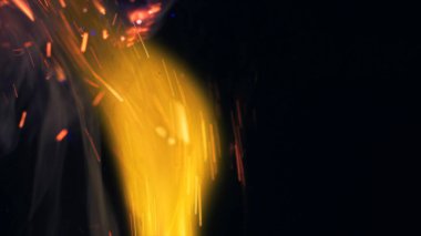 Şenlik ateşi kıvılcımlarının Macro fotoğrafı. Alevler patlar, patlamalar. Patlama mikro parlaklığı. Mini Havai fişekler. Kırmızı kamerada çekim hala siyah arkaplanda. Güzel sızıntılar kıvılcım posteri, afiş, duvar kağıdı, arkaplan, doku.