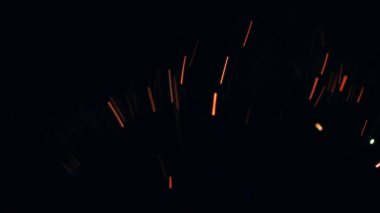 Şenlik ateşi kıvılcımlarının Macro fotoğrafı. Alevler patlar, patlamalar. Patlama mikro parlaklığı. Mini Havai fişekler. Kırmızı kamerada çekim hala siyah arkaplanda. Güzel sızıntılar kıvılcım posteri, afiş, duvar kağıdı, arkaplan, doku.