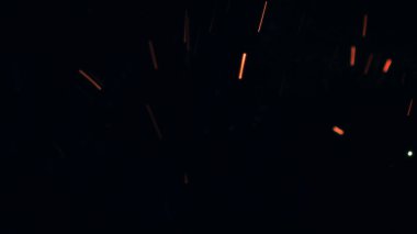 Şenlik ateşi kıvılcımlarının Macro fotoğrafı. Alevler patlar, patlamalar. Patlama mikro parlaklığı. Mini Havai fişekler. Kırmızı kamerada çekim hala siyah arkaplanda. Güzel sızıntılar kıvılcım posteri, afiş, duvar kağıdı, arkaplan, doku.