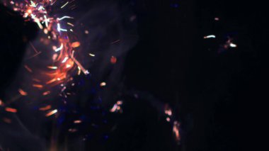 Şenlik ateşi kıvılcımlarının Macro fotoğrafı. Alevler patlar, patlamalar. Patlama mikro parlaklığı. Mini Havai fişekler. Kırmızı kamerada çekim hala siyah arkaplanda. Güzel sızıntılar kıvılcım posteri, afiş, duvar kağıdı, arkaplan, doku.