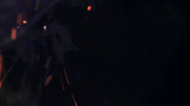 Şenlik ateşi kıvılcımlarının Macro fotoğrafı. Alevler patlar, patlamalar. Patlama mikro parlaklığı. Mini Havai fişekler. Kırmızı kamerada çekim hala siyah arkaplanda. Güzel sızıntılar kıvılcım posteri, afiş, duvar kağıdı, arkaplan, doku.