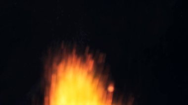 Şenlik ateşi kıvılcımlarının Macro fotoğrafı. Alevler patlar, patlamalar. Patlama mikro parlaklığı. Mini Havai fişekler. Kırmızı kamerada çekim hala siyah arkaplanda. Güzel sızıntılar kıvılcım posteri, afiş, duvar kağıdı, arkaplan, doku.