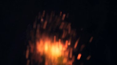 Şenlik ateşi kıvılcımlarının Macro fotoğrafı. Alevler patlar, patlamalar. Patlama mikro parlaklığı. Mini Havai fişekler. Kırmızı kamerada çekim hala siyah arkaplanda. Güzel sızıntılar kıvılcım posteri, afiş, duvar kağıdı, arkaplan, doku.