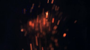 Şenlik ateşi kıvılcımlarının Macro fotoğrafı. Alevler patlar, patlamalar. Patlama mikro parlaklığı. Mini Havai fişekler. Kırmızı kamerada çekim hala siyah arkaplanda. Güzel sızıntılar kıvılcım posteri, afiş, duvar kağıdı, arkaplan, doku.