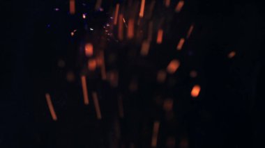 Şenlik ateşi kıvılcımlarının Macro fotoğrafı. Alevler patlar, patlamalar. Patlama mikro parlaklığı. Mini Havai fişekler. Kırmızı kamerada çekim hala siyah arkaplanda. Güzel sızıntılar kıvılcım posteri, afiş, duvar kağıdı, arkaplan, doku.