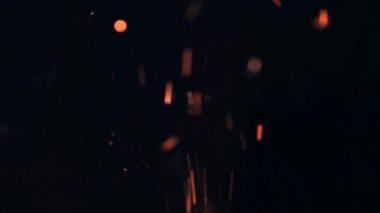 Şenlik ateşi kıvılcımlarının Macro fotoğrafı. Alevler patlar, patlamalar. Patlama mikro parlaklığı. Mini Havai fişekler. Kırmızı kamerada çekim hala siyah arkaplanda. Güzel sızıntılar kıvılcım posteri, afiş, duvar kağıdı, arkaplan, doku.