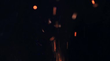 Şenlik ateşi kıvılcımlarının Macro fotoğrafı. Alevler patlar, patlamalar. Patlama mikro parlaklığı. Mini Havai fişekler. Kırmızı kamerada çekim hala siyah arkaplanda. Güzel sızıntılar kıvılcım posteri, afiş, duvar kağıdı, arkaplan, doku.