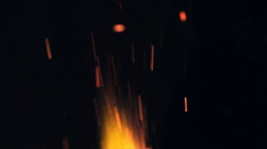 Şenlik ateşi kıvılcımlarının Macro fotoğrafı. Alevler patlar, patlamalar. Patlama mikro parlaklığı. Mini Havai fişekler. Kırmızı kamerada çekim hala siyah arkaplanda. Güzel sızıntılar kıvılcım posteri, afiş, duvar kağıdı, arkaplan, doku.