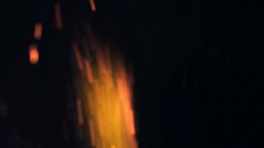 Şenlik ateşi kıvılcımlarının Macro fotoğrafı. Alevler patlar, patlamalar. Patlama mikro parlaklığı. Mini Havai fişekler. Kırmızı kamerada çekim hala siyah arkaplanda. Güzel sızıntılar kıvılcım posteri, afiş, duvar kağıdı, arkaplan, doku.