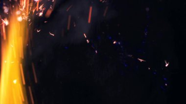 Şenlik ateşi kıvılcımlarının Macro fotoğrafı. Alevler patlar, patlamalar. Patlama mikro parlaklığı. Mini Havai fişekler. Kırmızı kamerada çekim hala siyah arkaplanda. Güzel sızıntılar kıvılcım posteri, afiş, duvar kağıdı, arkaplan, doku.