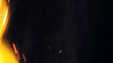 Şenlik ateşi kıvılcımlarının Macro fotoğrafı. Alevler patlar, patlamalar. Patlama mikro parlaklığı. Mini Havai fişekler. Kırmızı kamerada çekim hala siyah arkaplanda. Güzel sızıntılar kıvılcım posteri, afiş, duvar kağıdı, arkaplan, doku.