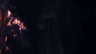 Şenlik ateşi kıvılcımlarının Macro fotoğrafı. Alevler patlar, patlamalar. Patlama mikro parlaklığı. Mini Havai fişekler. Kırmızı kamerada çekim hala siyah arkaplanda. Güzel sızıntılar kıvılcım posteri, afiş, duvar kağıdı, arkaplan, doku.