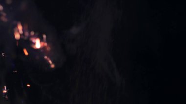 Şenlik ateşi kıvılcımlarının Macro fotoğrafı. Alevler patlar, patlamalar. Patlama mikro parlaklığı. Mini Havai fişekler. Kırmızı kamerada çekim hala siyah arkaplanda. Güzel sızıntılar kıvılcım posteri, afiş, duvar kağıdı, arkaplan, doku.