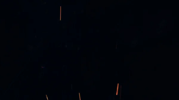 篝火火花的宏观照片 火焰熊熊燃烧 爆炸的微小火花 迷你烟花 在红色相机上拍摄仍然在黑色背景 美丽的泄漏覆盖着星星之火海报 — 图库照片