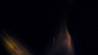 Şenlik ateşi kıvılcımlarının Macro fotoğrafı. Alevler patlar, patlamalar. Patlama mikro parlaklığı. Mini Havai fişekler. Kırmızı kamerada çekim hala siyah arkaplanda. Güzel sızıntılar kıvılcım posteri, afiş, duvar kağıdı, arkaplan, doku.