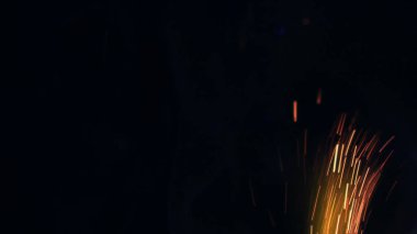 Şenlik ateşi kıvılcımlarının Macro fotoğrafı. Alevler patlar, patlamalar. Patlama mikro parlaklığı. Mini Havai fişekler. Kırmızı kamerada çekim hala siyah arkaplanda. Güzel sızıntılar kıvılcım posteri, afiş, duvar kağıdı, arkaplan, doku.
