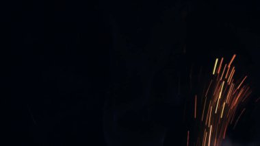 Şenlik ateşi kıvılcımlarının Macro fotoğrafı. Alevler patlar, patlamalar. Patlama mikro parlaklığı. Mini Havai fişekler. Kırmızı kamerada çekim hala siyah arkaplanda. Güzel sızıntılar kıvılcım posteri, afiş, duvar kağıdı, arkaplan, doku.