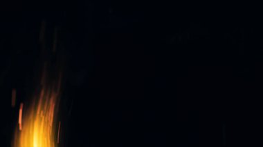 Şenlik ateşi kıvılcımlarının Macro fotoğrafı. Alevler patlar, patlamalar. Patlama mikro parlaklığı. Mini Havai fişekler. Kırmızı kamerada çekim hala siyah arkaplanda. Güzel sızıntılar kıvılcım posteri, afiş, duvar kağıdı, arkaplan, doku.