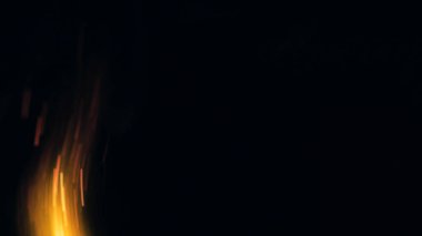 Şenlik ateşi kıvılcımlarının Macro fotoğrafı. Alevler patlar, patlamalar. Patlama mikro parlaklığı. Mini Havai fişekler. Kırmızı kamerada çekim hala siyah arkaplanda. Güzel sızıntılar kıvılcım posteri, afiş, duvar kağıdı, arkaplan, doku.