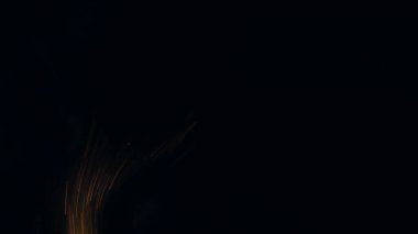 Şenlik ateşi kıvılcımlarının Macro fotoğrafı. Alevler patlar, patlamalar. Patlama mikro parlaklığı. Mini Havai fişekler. Kırmızı kamerada çekim hala siyah arkaplanda. Güzel sızıntılar kıvılcım posteri, afiş, duvar kağıdı, arkaplan, doku.