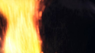 Şenlik ateşi kıvılcımlarının Macro fotoğrafı. Alevler patlar, patlamalar. Patlama mikro parlaklığı. Mini Havai fişekler. Kırmızı kamerada çekim hala siyah arkaplanda. Güzel sızıntılar kıvılcım posteri, afiş, duvar kağıdı, arkaplan, doku.