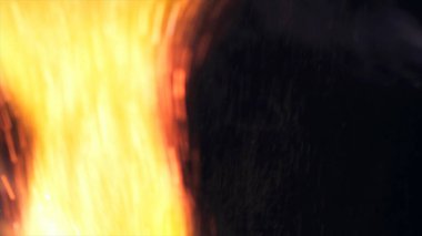 Şenlik ateşi kıvılcımlarının Macro fotoğrafı. Alevler patlar, patlamalar. Patlama mikro parlaklığı. Mini Havai fişekler. Kırmızı kamerada çekim hala siyah arkaplanda. Güzel sızıntılar kıvılcım posteri, afiş, duvar kağıdı, arkaplan, doku.