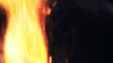 Şenlik ateşi kıvılcımlarının Macro fotoğrafı. Alevler patlar, patlamalar. Patlama mikro parlaklığı. Mini Havai fişekler. Kırmızı kamerada çekim hala siyah arkaplanda. Güzel sızıntılar kıvılcım posteri, afiş, duvar kağıdı, arkaplan, doku.