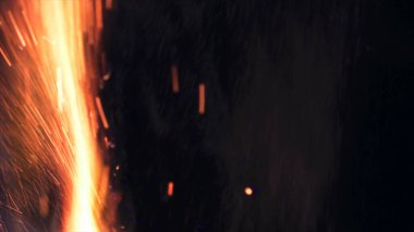 Şenlik ateşi kıvılcımlarının Macro fotoğrafı. Alevler patlar, patlamalar. Patlama mikro parlaklığı. Mini Havai fişekler. Kırmızı kamerada çekim hala siyah arkaplanda. Güzel sızıntılar kıvılcım posteri, afiş, duvar kağıdı, arkaplan, doku.