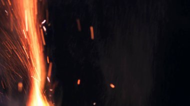 Şenlik ateşi kıvılcımlarının Macro fotoğrafı. Alevler patlar, patlamalar. Patlama mikro parlaklığı. Mini Havai fişekler. Kırmızı kamerada çekim hala siyah arkaplanda. Güzel sızıntılar kıvılcım posteri, afiş, duvar kağıdı, arkaplan, doku.