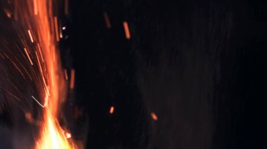 Şenlik ateşi kıvılcımlarının Macro fotoğrafı. Alevler patlar, patlamalar. Patlama mikro parlaklığı. Mini Havai fişekler. Kırmızı kamerada çekim hala siyah arkaplanda. Güzel sızıntılar kıvılcım posteri, afiş, duvar kağıdı, arkaplan, doku.