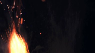 Şenlik ateşi kıvılcımlarının Macro fotoğrafı. Alevler patlar, patlamalar. Patlama mikro parlaklığı. Mini Havai fişekler. Kırmızı kamerada çekim hala siyah arkaplanda. Güzel sızıntılar kıvılcım posteri, afiş, duvar kağıdı, arkaplan, doku.