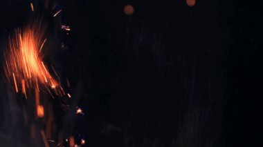 Şenlik ateşi kıvılcımlarının Macro fotoğrafı. Alevler patlar, patlamalar. Patlama mikro parlaklığı. Mini Havai fişekler. Kırmızı kamerada çekim hala siyah arkaplanda. Güzel sızıntılar kıvılcım posteri, afiş, duvar kağıdı, arkaplan, doku.