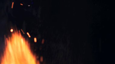 Şenlik ateşi kıvılcımlarının Macro fotoğrafı. Alevler patlar, patlamalar. Patlama mikro parlaklığı. Mini Havai fişekler. Kırmızı kamerada çekim hala siyah arkaplanda. Güzel sızıntılar kıvılcım posteri, afiş, duvar kağıdı, arkaplan, doku.