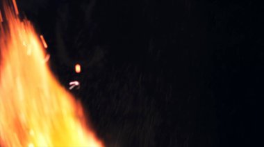 Şenlik ateşi kıvılcımlarının Macro fotoğrafı. Alevler patlar, patlamalar. Patlama mikro parlaklığı. Mini Havai fişekler. Kırmızı kamerada çekim hala siyah arkaplanda. Güzel sızıntılar kıvılcım posteri, afiş, duvar kağıdı, arkaplan, doku.